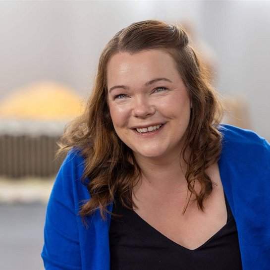 Portrait der lächelnden Hebamme Maria Werner in einem hellen Raum.
