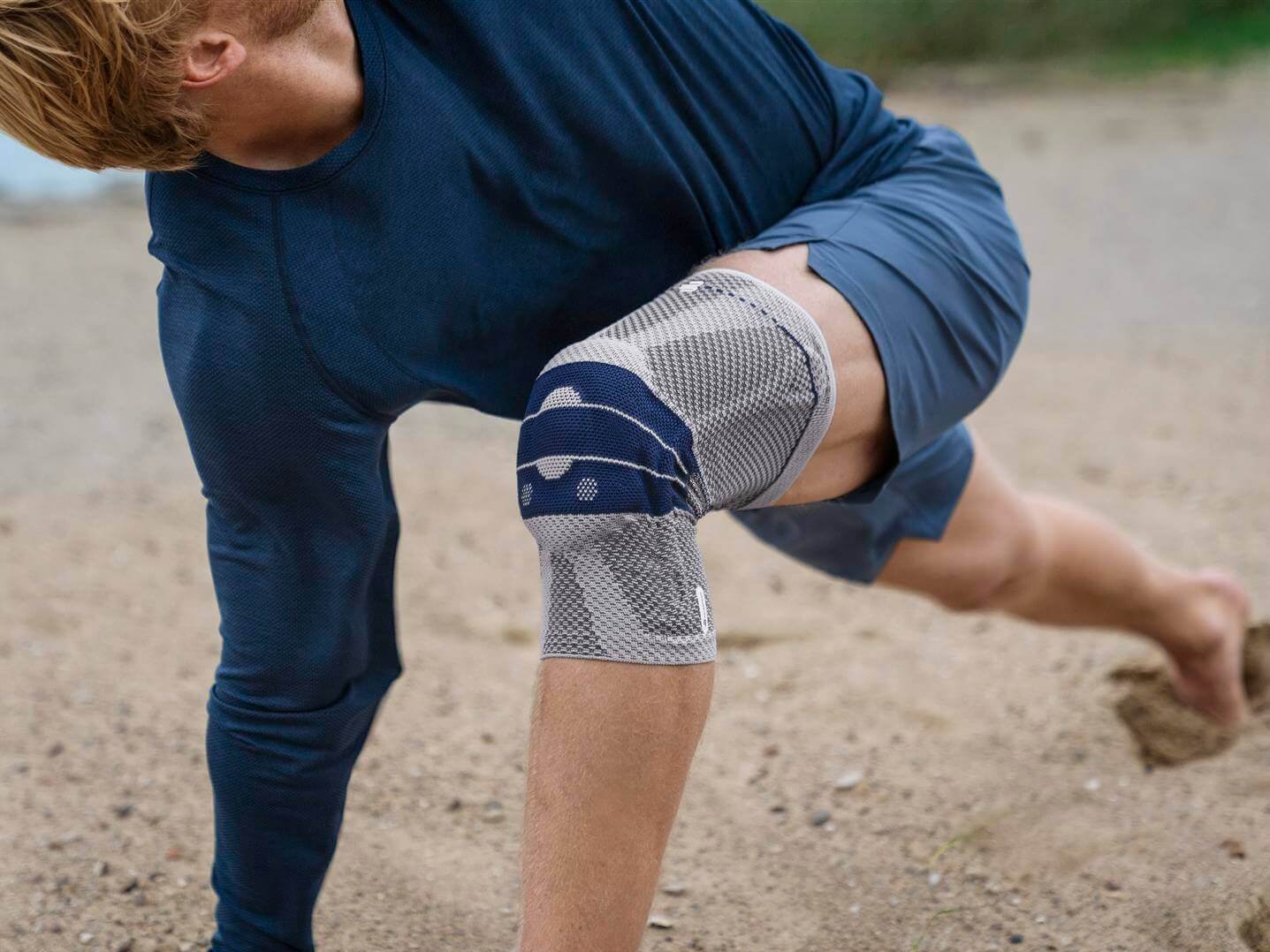 Bildausschnitt eines Mannes mit GenuTrain Bandage am Knie. Diese bietet Entlastung und stabilisiert das Knie, um Schmerzen zu lindern.