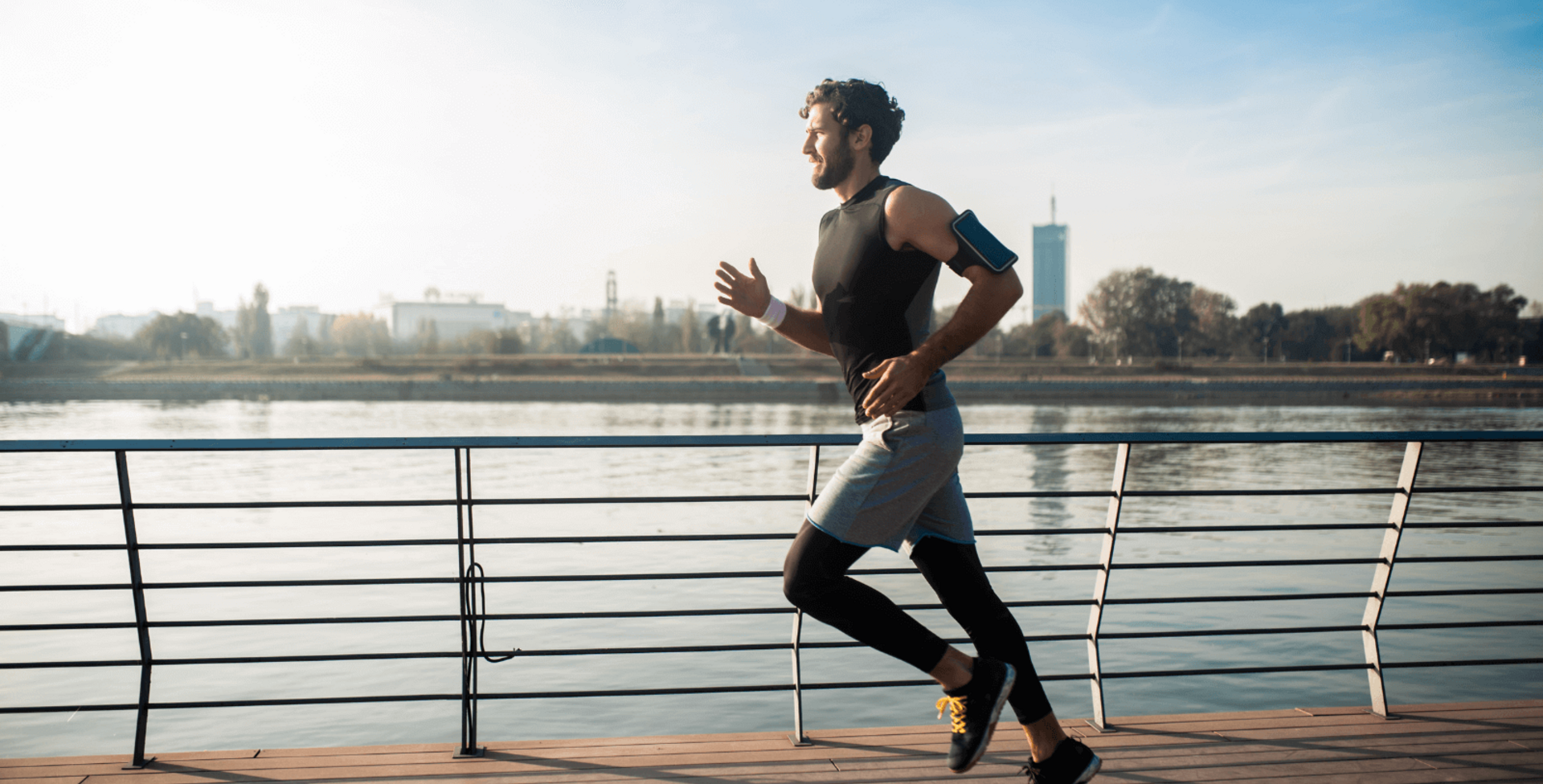 Auf dem Bild ist ein Mann zu sehen, der an einem Fluss entlang joggt.