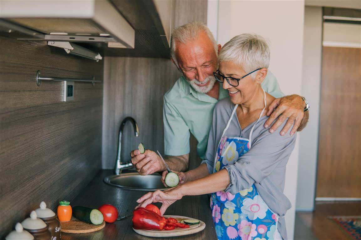 Gesunde Ernährung bei Arthrose Das Bild zeigt, ein Mann und eine Frau, die zusammen kochen. Wir erklären, warum eine gesunde Ernährung bei Arthrose wichtig ist und wie diese sich gestalten sollte.